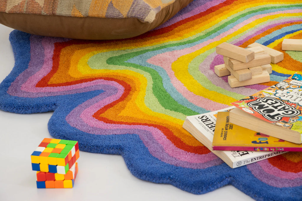 Colorful wavy rug with toys and books on a white background
